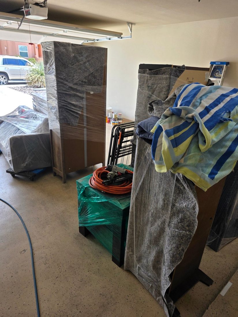 Wrapped staging furniture and supplies staged in the garage during delivery