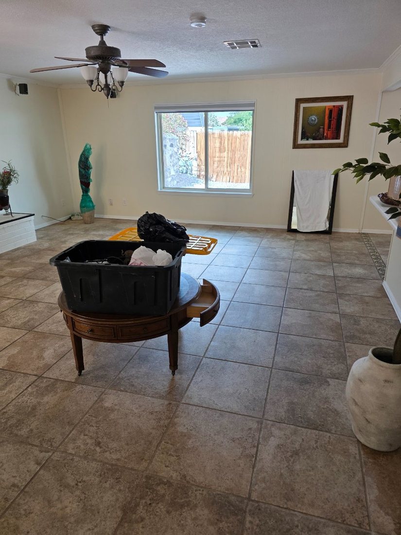 Living room mid-staging with bins, rug and coffee table being set