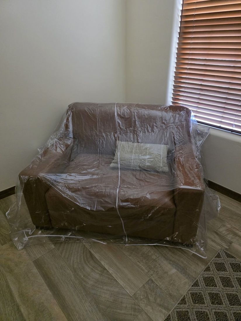 Sofa wrapped in plastic waiting to be unwrapped and placed